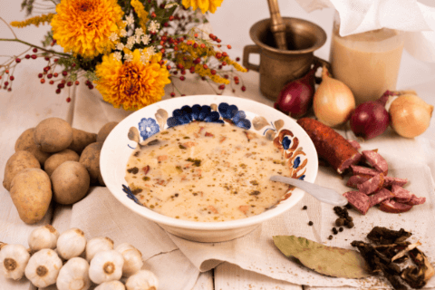 stół z dekoracją warzyw i kiełbas oraz talerz z zupą