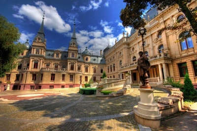 View of the courtyard of the palace in Kutno. Bright building, gravel paths, greenery.