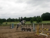 Siwy koń i amazonka w trakcie skoku, podczas zawodów.